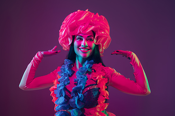 Image showing Attractive hawaiian brunette model on purple studio background in neon light