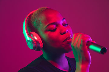 Image showing African-american young woman\'s portrait on purple pink background