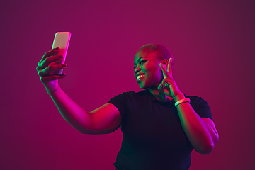 Image showing African-american young woman\'s portrait on purple pink background