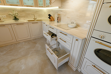 Image showing Open drawer in cabinet at luxury beige and gold classic kitchen furniture