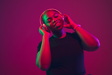 Image showing African-american young woman\'s portrait on purple pink background