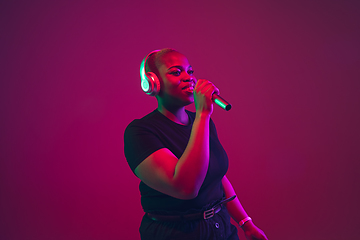 Image showing African-american young woman\'s portrait on purple pink background