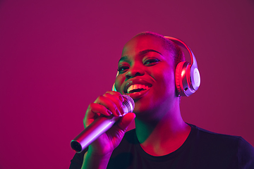 Image showing African-american young woman\'s portrait on purple pink background