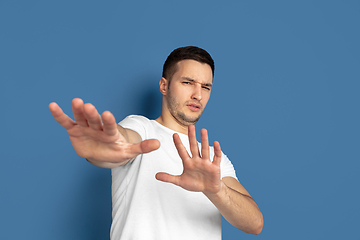 Image showing Caucasian young man\'s portrait on blue studio background