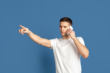 Image showing Caucasian young man\'s portrait on blue studio background