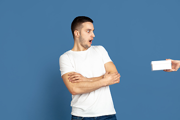 Image showing Caucasian young man\'s portrait on blue studio background