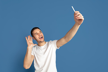 Image showing Caucasian young man\'s portrait on blue studio background