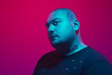 Image showing Portrait of a guy with colorful neon light on red background - cyberpunk concept