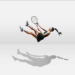 Image showing Young caucasian professional sportswoman levitating, flying while playing tennis isolated on white background