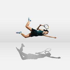 Image showing Young caucasian professional sportswoman levitating, flying while playing tennis isolated on white background