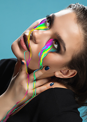 Image showing Portrait of young beautiful woman with neon, fluid tears from eyes. Concept of fashion and beauty, emotions and feelings, modern design