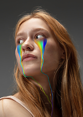 Image showing Portrait of young beautiful woman with neon, fluid tears from eyes. Concept of fashion and beauty, emotions and feelings, modern design