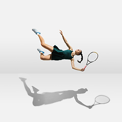 Image showing Young caucasian professional sportswoman levitating, flying while playing tennis isolated on white background