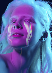 Image showing Portrait of young beautiful woman with neon, fluid tears from eyes. Concept of fashion and beauty, emotions and feelings, modern design