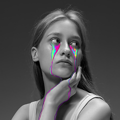 Image showing Portrait of young beautiful woman with neon, fluid tears from eyes. Concept of fashion and beauty, emotions and feelings, modern design