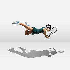 Image showing Young caucasian professional sportswoman levitating, flying while playing tennis isolated on white background