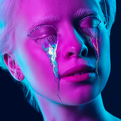 Image showing Portrait of young beautiful woman with neon, fluid tears from eyes. Concept of fashion and beauty, emotions and feelings, modern design