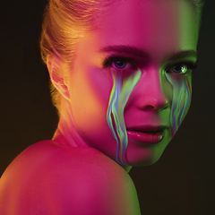 Image showing Portrait of young beautiful woman with neon, fluid tears from eyes. Concept of fashion and beauty, emotions and feelings, modern design