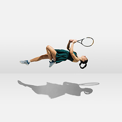 Image showing Young caucasian professional sportswoman levitating, flying while playing tennis isolated on white background