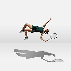 Image showing Young caucasian professional sportswoman levitating, flying while playing tennis isolated on white background