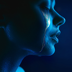 Image showing Portrait of young beautiful woman with neon, fluid tears from eyes. Concept of fashion and beauty, emotions and feelings, modern design