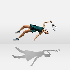 Image showing Young caucasian professional sportswoman levitating, flying while playing tennis isolated on white background