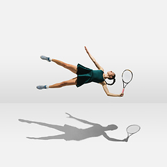 Image showing Young caucasian professional sportswoman levitating, flying while playing tennis isolated on white background