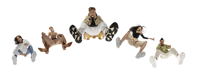 Image showing Young stylish people in modern street style outfit isolated on white background, view from the bottom. Fashionable models, musicians, rappers performing.