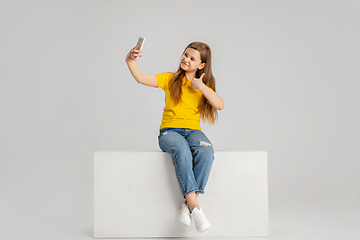 Image showing Happy kid, girl isolated on white studio background. Looks happy, cheerful, sincere. Copyspace. Childhood, education, emotions concept