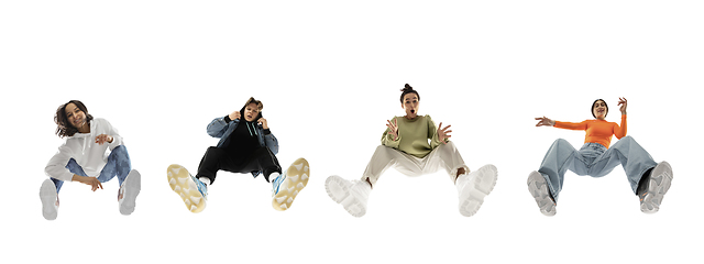 Image showing Young stylish people in modern street style outfit isolated on white background, view from the bottom. Fashionable models, musicians, rappers performing.