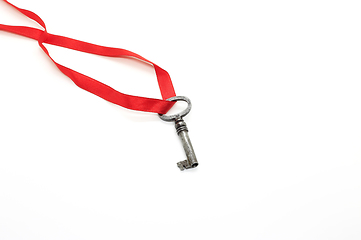 Image showing Vintage silver key on red ribbon on white background