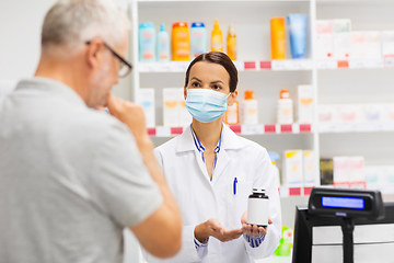 Image showing apothecary in mask showing drug to man at pharmacy