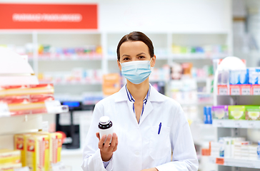 Image showing female apothecary in mask with drug at pharmacy