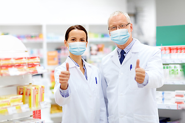 Image showing apothecaries in masks show thumbs up at pharmacy