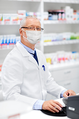 Image showing senior apothecary in mask at pharmacy