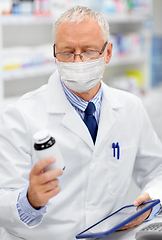 Image showing old apothecary in mask with tablet pc at pharmacy