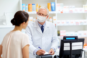 Image showing senior apothecary in mask and customer at pharmacy