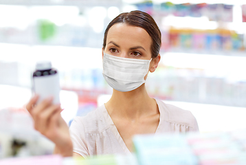 Image showing female customer in mask with medicine at pharmacy