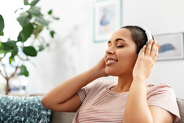 Image showing woman in headphones listening to music at home