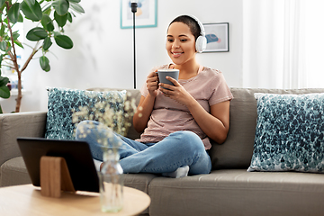 Image showing woman with tablet pc drinking coffee at home
