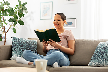 Image showing happy african american woman reading book at home