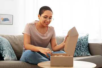 Image showing african american woman opening parcel box at home