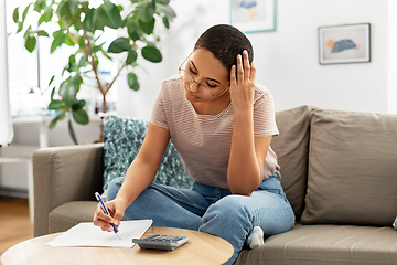 Image showing african woman with papers and calculator at home