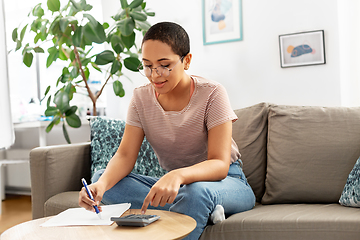 Image showing african woman with papers and calculator at home