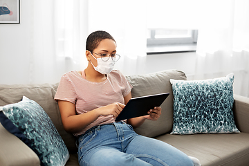 Image showing woman in medical mask with tablet pc at home