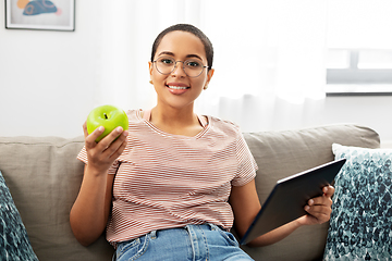 Image showing african woman with tablet pc and apple at home