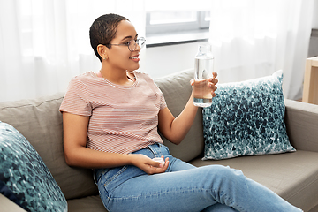 Image showing african american woman with water in glass bottle