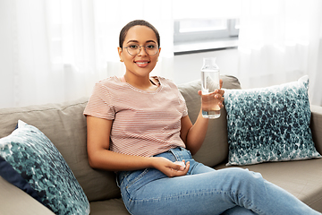 Image showing african american woman with water in glass bottle