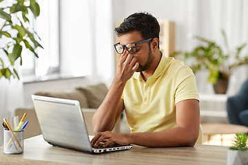 Image showing tired man with laptop working at home office