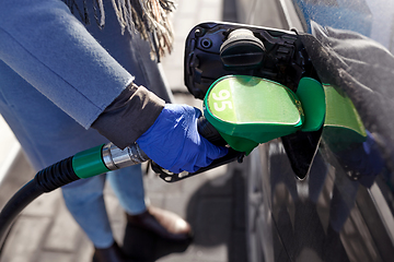 Image showing close up of hand in glove filling car with petrol